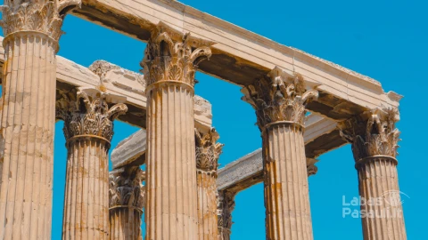 low-angle-shot-old-greek-stone-pillars-with-clear-blue-sky