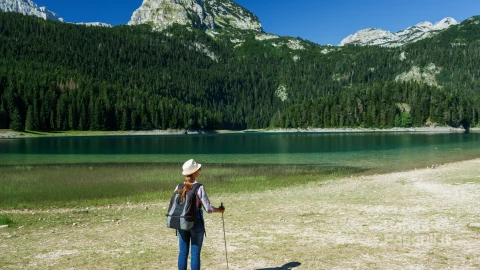 woman-hiker-with-backpack-walking-stick-black-lake-durmitor-national-park-montenegro