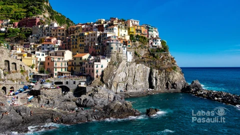 beautiful-shot-colorful-apartment-buildings-rocky-hill-seashore-blue-sky-min