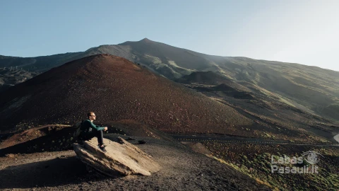 man-sitting-rock-enjoying-beautiful-landscape-volcano-etna-sicily-min