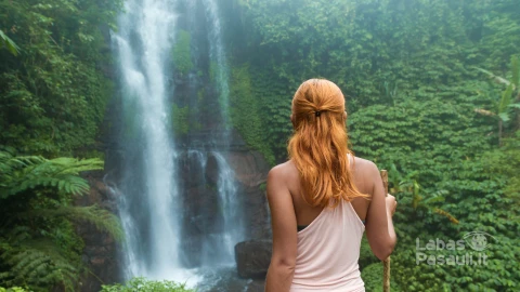 female-adventurer-looking-waterfall-min